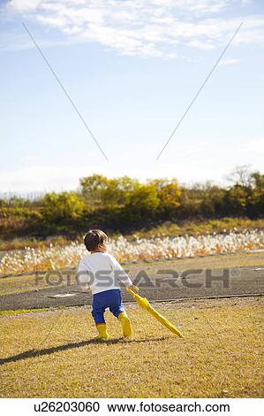Boy with Yellow Umbrella in Field View Large Photo Image Stock Image - Boy with Yellow Umbrella in Field. Fotosearch