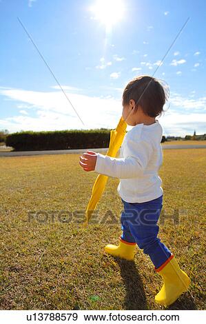 Stock Photo - Boy with Yellow Umbrella in Field. Fotosearch