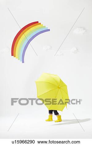 Stock Image - Boy with Yellow Umbrella Under Rainbow. Fotosearch