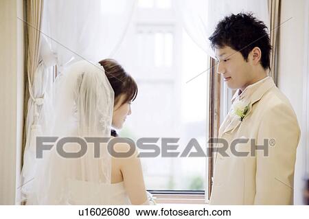 Stock Image - Bride and bridegroom standing face to face. Fotosearch