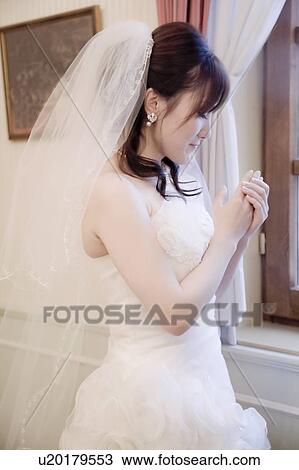 Bride standing by the window View Large Photo Image Stock Image - Bride standing by the window. Fotosearch