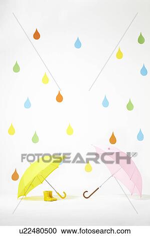Stock Image - Colourful Raindrops Falling on Umbrellas and Rubber Boots. Fotosearch