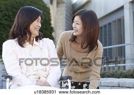 Stock Image - Daughter Visitng Mother in Hospital. Fotosearch