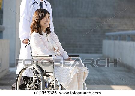 Doctor Pushing Woman in Wheelchair View Large Photo Image Stock Photography - Doctor Pushing Woman in Wheelchair. Fotosearch