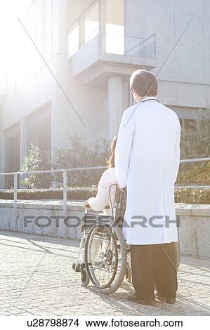 Doctor with Patient in Wheelchair View Large Photo Image Picture - Doctor with Patient in Wheelchair. Fotosearch