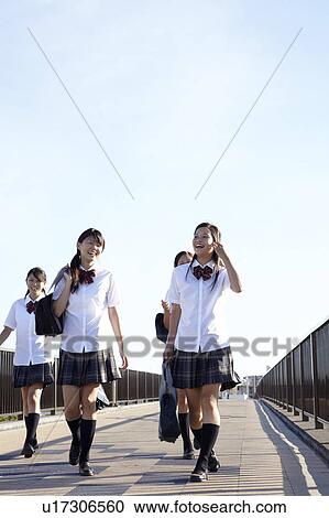 Stock Image - Four Schoolgirls Walking on Bridge. Fotosearch