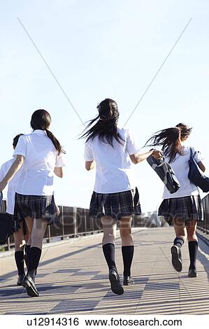 Stock Photograph - Four Schoolgirls Walking on Bridge. Fotosearch