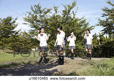 Stock Photography - Four Teenage Schoolgirls Walking in Park. Fotosearch