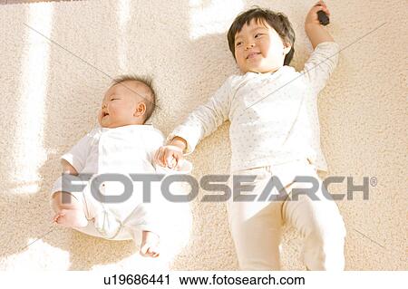 Girl and baby lying down View Large Photo Image Stock Image - Girl and baby lying down. Fotosearch