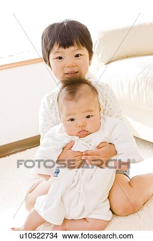 Girl embracing a baby View Large Photo Image Picture - Girl embracing a baby. Fotosearch