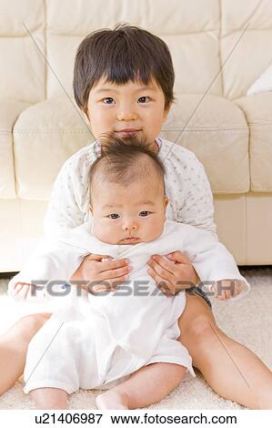 Stock Photo - Girl embracing a baby. Fotosearch