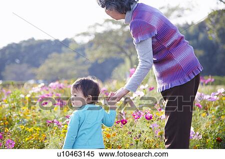 Stock Photography - Grandmother and Grandson by Flowers. Fotosearch