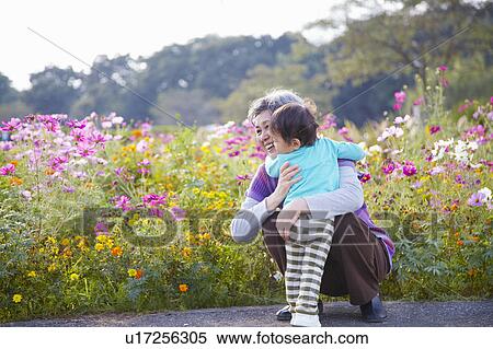 Stock Photography - Grandmother and Grandson by Flowers. Fotosearch
