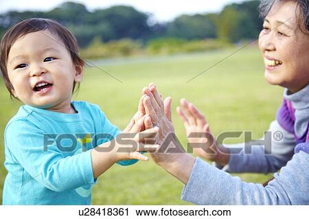 Stock Image - Grandmother and Grandson High Fiving. Fotosearch