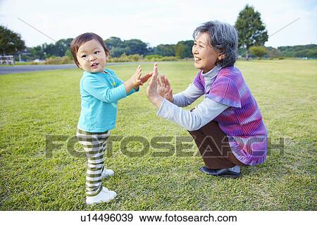 Stock Photo - Grandmother and Grandson High Fiving. Fotosearch