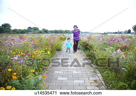 Stock Image - Grandmother and Grandson Walking in Path. Fotosearch