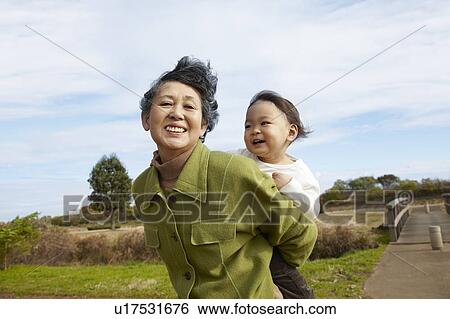 Stock Photograph - Grandmother Carrying Granson. Fotosearch