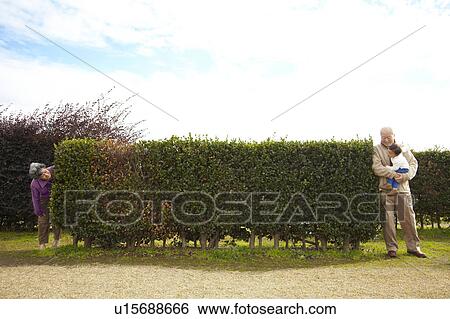 Stock Photograph - Grandparents and Grandson Playing Hide and Seek. Fotosearch
