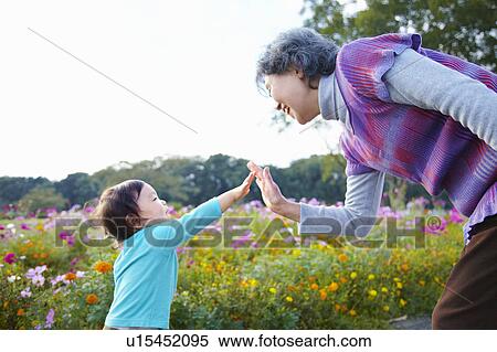 Stock Photography - Grandson and Grandmother High Fiving. Fotosearch