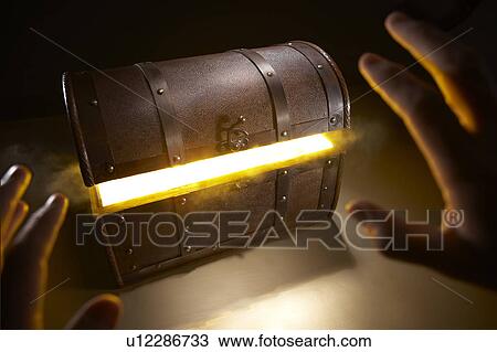 Stock Image - Hand approaching treasure chest. Fotosearch