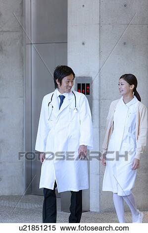 Stock Photography - Male Doctor and Femlae Nurse Walking. Fotosearch