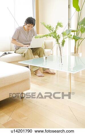 Man in living room using laptop View Large Photo Image Stock Image - Man in living room using laptop. Fotosearch