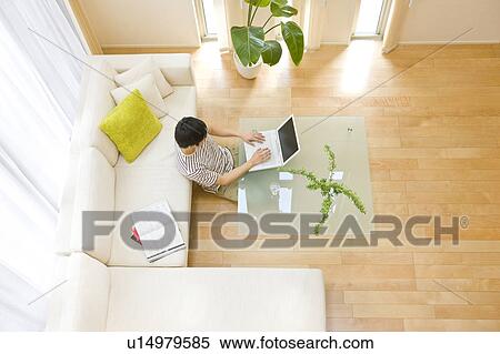 Man in living room using laptop View Large Photo Image Stock Photography - Man in living room using laptop. Fotosearch