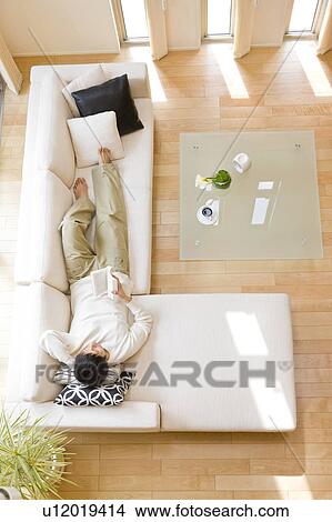Man relaxing on sofa View Large Photo Image Picture - Man relaxing on sofa. Fotosearch