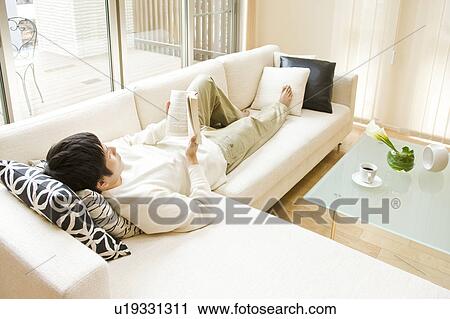 Man relaxing on sofa View Large Photo Image Stock Image - Man relaxing on sofa. Fotosearch
