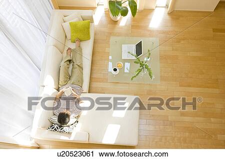 Man relaxing on sofa View Large Photo Image Stock Image - Man relaxing on sofa. Fotosearch