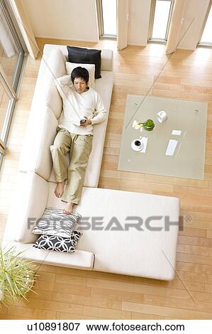 Man relaxing on sofa View Large Photo Image Stock Photo - Man relaxing on sofa. Fotosearch