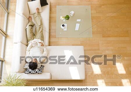 Stock Photo - Man relaxing on sofa. Fotosearch
