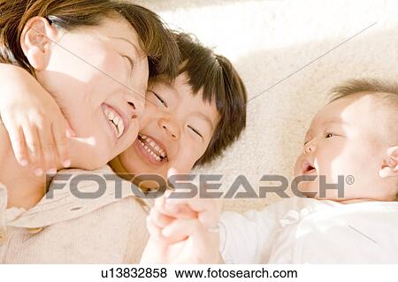 Mother and kids lying down and smiling View Large Photo Image Stock Photo - Mother and kids lying down and smiling. Fotosearch