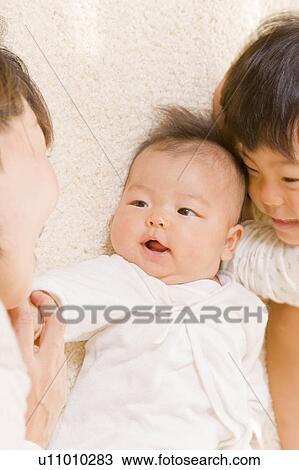Stock Image - Mother and kids lying down. Fotosearch