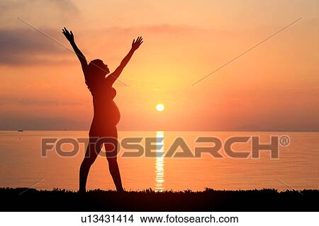 Pregnant Woman Stretching Against Sun View Large Photo Image Picture - Pregnant Woman Stretching Against Sun. Fotosearch