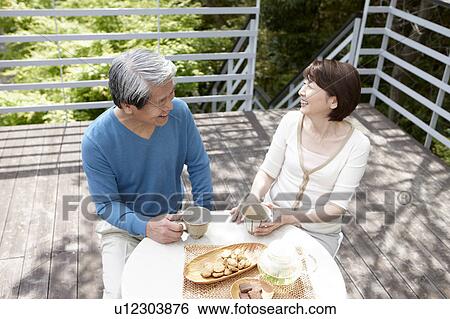 Stock Photograph - Senior Couple Having Tea at Terrace. Fotosearch