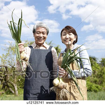 Stock Image - Senior Couple Holding Onion Crop. Fotosearch