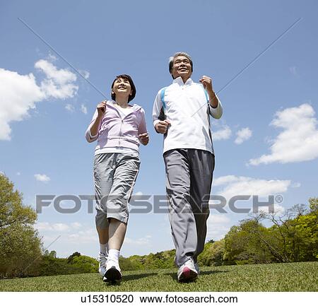 Stock Image - Senior Couple Jogging in Park. Fotosearch