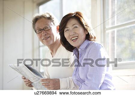 Picture - Senior Couple Reading Newspaper at Rail Station. Fotosearch