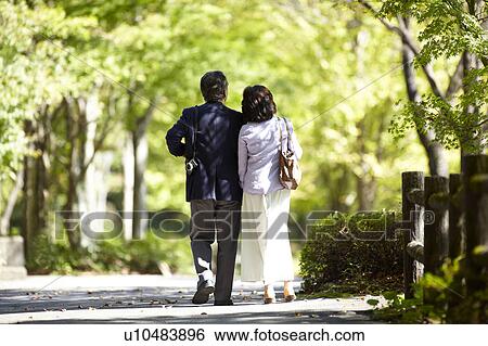 Stock Photograph - Senior Couple Walking in Park. Fotosearch