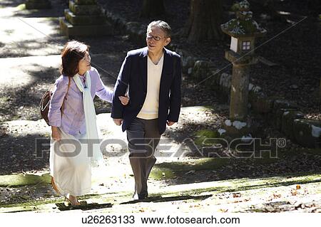 Stock Image - Senior Couple Walking in Temple Yard. Fotosearch