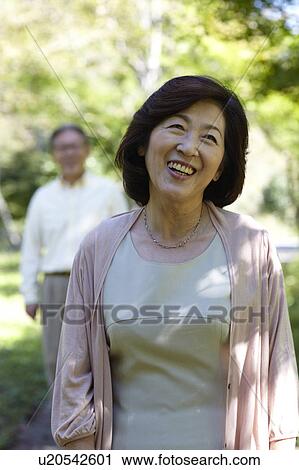 Stock Image - Senior Woman with Husband in Background. Fotosearch