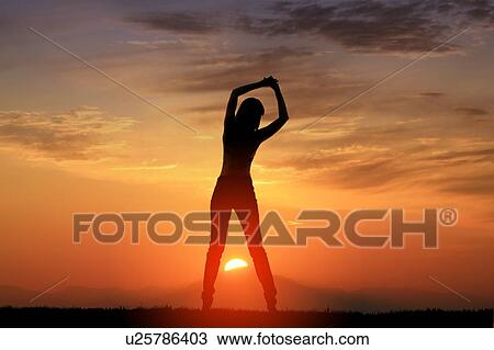 Stock Image - Silhouette of woman stretching. Fotosearch
