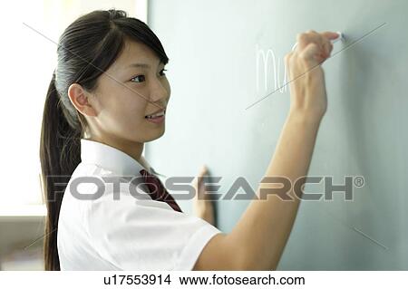 Picture - Teenage girl Writing on Blackboard. Fotosearch