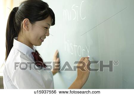 Stock Photograph - Teenage girl Writing on Blackboard. Fotosearch