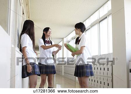 Stock Photograph - Three Female Students Talking in Corridor. Fotosearch