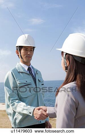 Two Businesspeople with Hardhats Shaking Hands View Large Photo Image Stock Image - Two Businesspeople with Hardhats Shaking Hands. Fotosearch