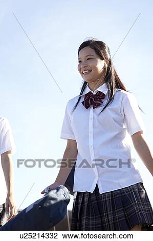 Stock Image - Two Schoolgirls Walking on Bridge. Fotosearch