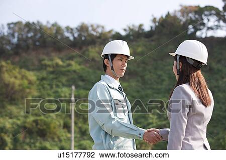 Woman and Man Shaking Hands at Construction Site View Large Photo Image Stock Image - Woman and Man Shaking Hands at Construction Site. Fotosearch