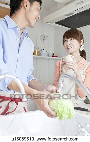 Stock Image - Young couple at kitchen . Fotosearch